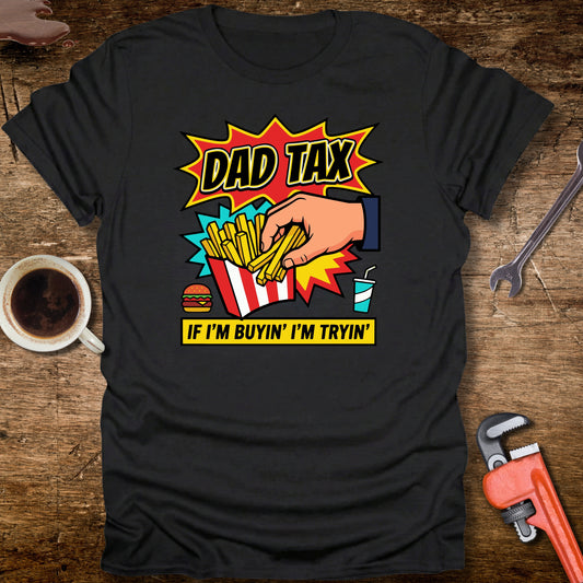 Black t-shirt with colorful graphic and text on a wooden surface with tools and a cup.