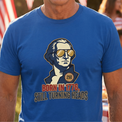 Man wearing a blue t-shirt with a graphic design and text, standing outdoors with flags in the background.