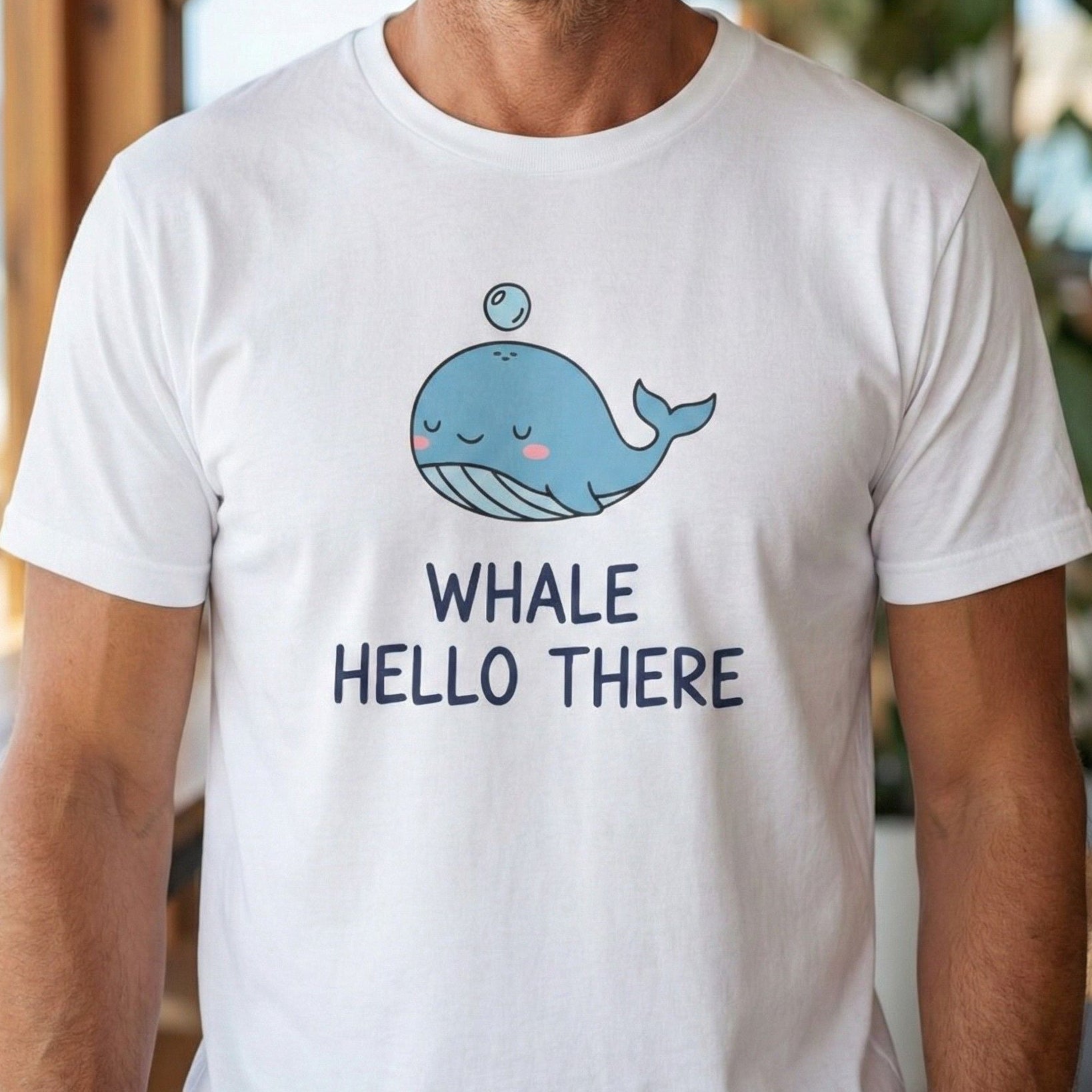 Man wearing a white t-shirt with a whale graphic and text in an indoor setting.