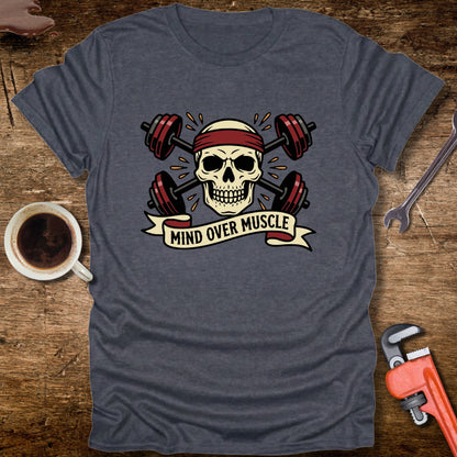 Gray t-shirt with skull and barbell design on a wooden surface with coffee and tools.