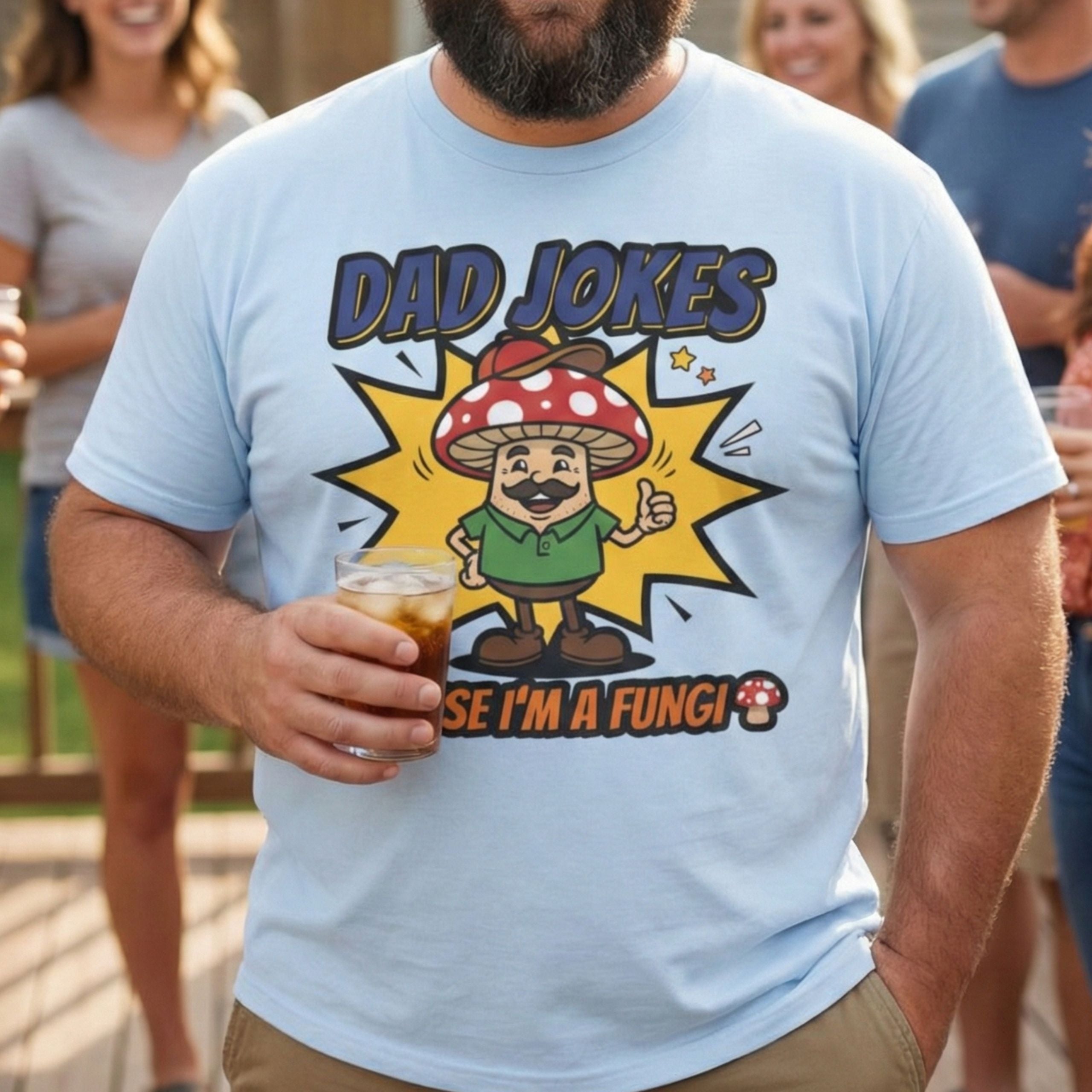 Man wearing a light blue t-shirt with a 'Dad Jokes' graphic design, holding a drink outdoors.