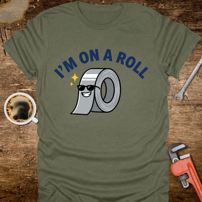 Green t-shirt with 'I'm on a Roll' graphic design on a wooden surface with coffee and tools.