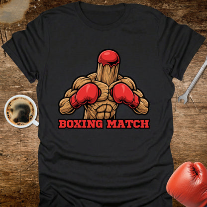Black t-shirt with boxing-themed graphic on a wooden surface with coffee and gloves.