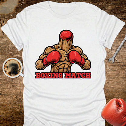 White t-shirt with boxing-themed graphic on a wooden surface with coffee and gloves.