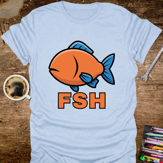 Light blue t-shirt with a cartoon fish and 'FSH' text on a wooden surface with a coffee cup and tools.
