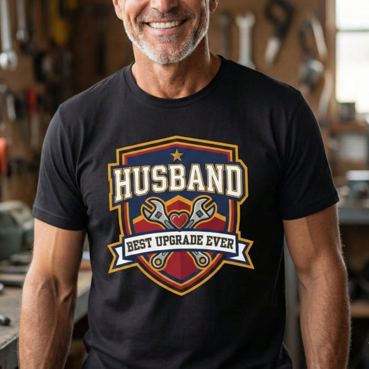 Man wearing a black t-shirt with 'Husband Best Upgrade Ever' graphic in a workshop.