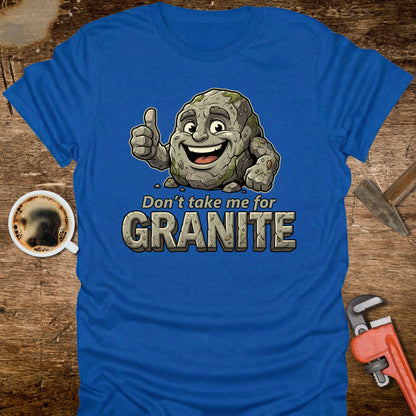 Blue t-shirt with a cartoon rock character and text 'Don't take me for Granite' on a wooden background.