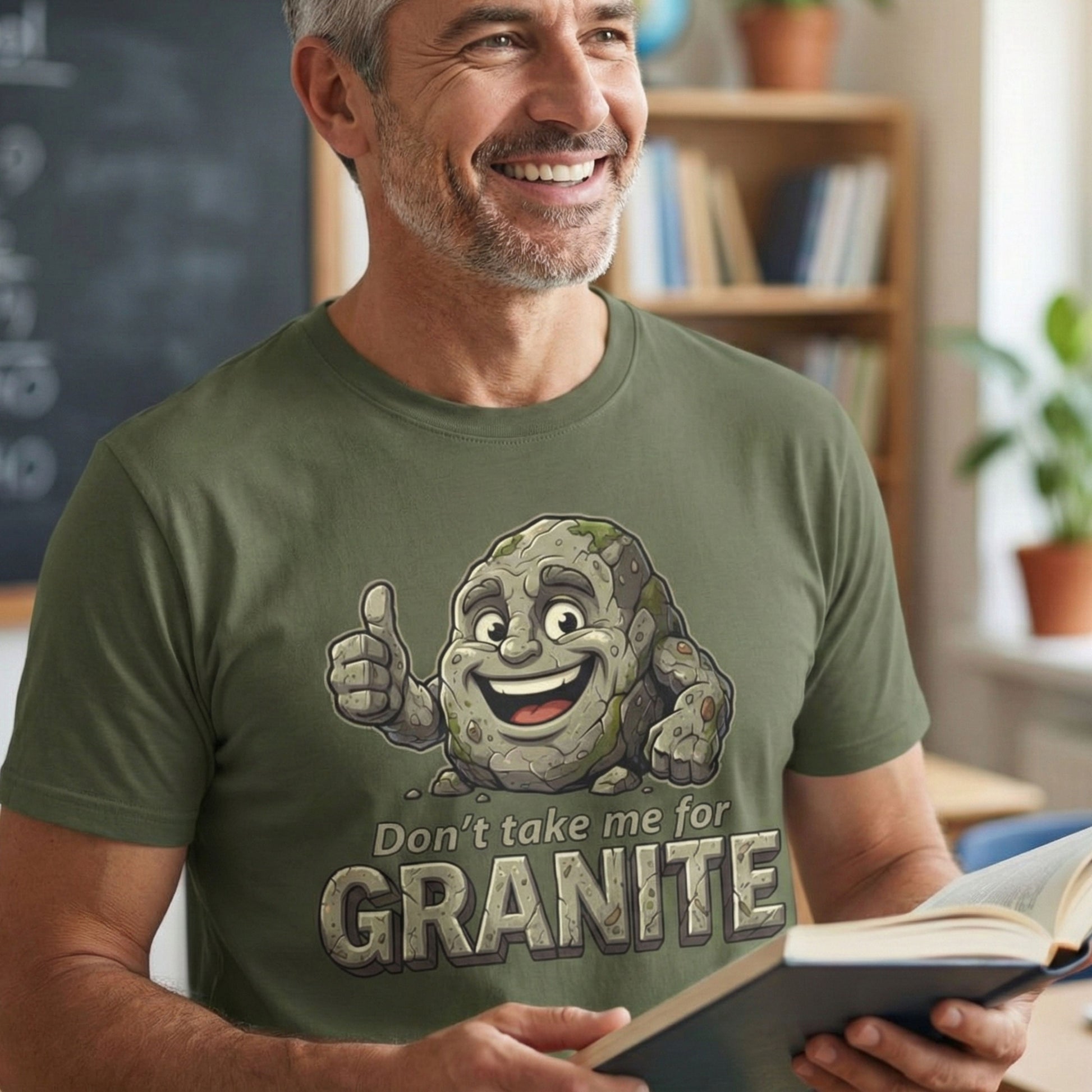 Man wearing a green t-shirt with a cartoon character and text, holding a book in a room.