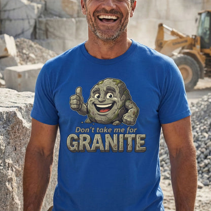 Man wearing a blue t-shirt with a cartoon stone character and text, standing in a construction site.