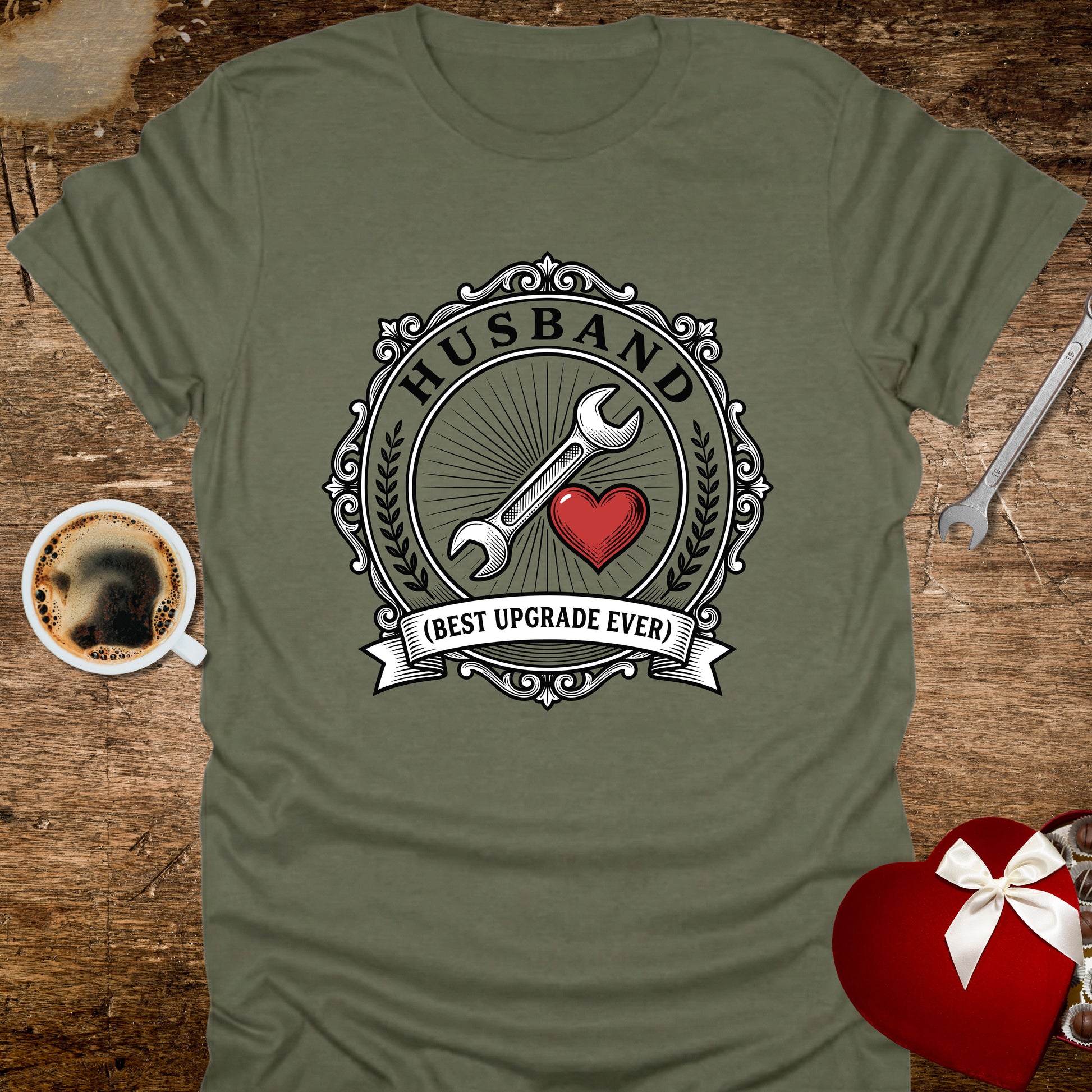 Green t-shirt with a graphic design featuring a wrench, heart, and text on a wooden surface with coffee and tools.