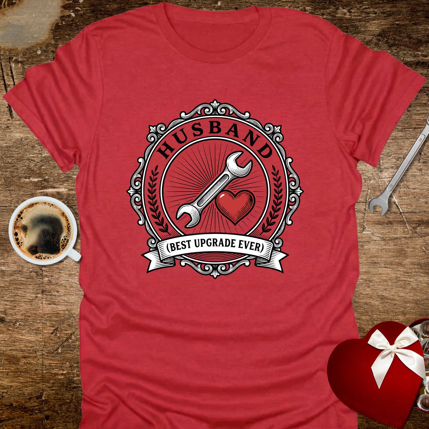 Red t-shirt with 'Husband (Best Upgrade Ever)' design on a wooden surface with coffee and gift.