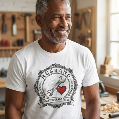 Man wearing a white t-shirt with a 'Husband' graphic design in a workshop.
