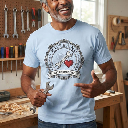 Man wearing a light blue t-shirt with a graphic design, holding a wrench in a workshop.