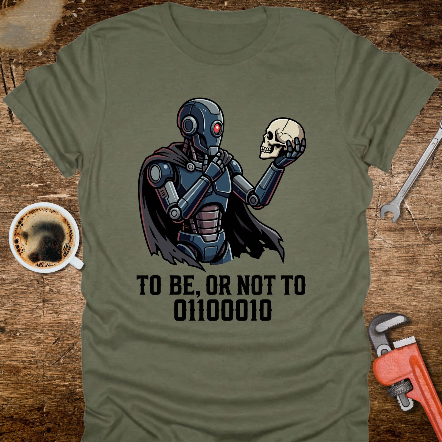 Green t-shirt with a robot holding a skull design and text on a wooden surface with coffee and tools.