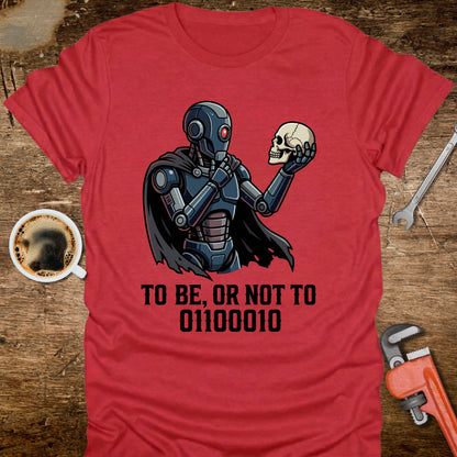 Red t-shirt with a robot holding a skull and text on a wooden surface with tools and coffee.