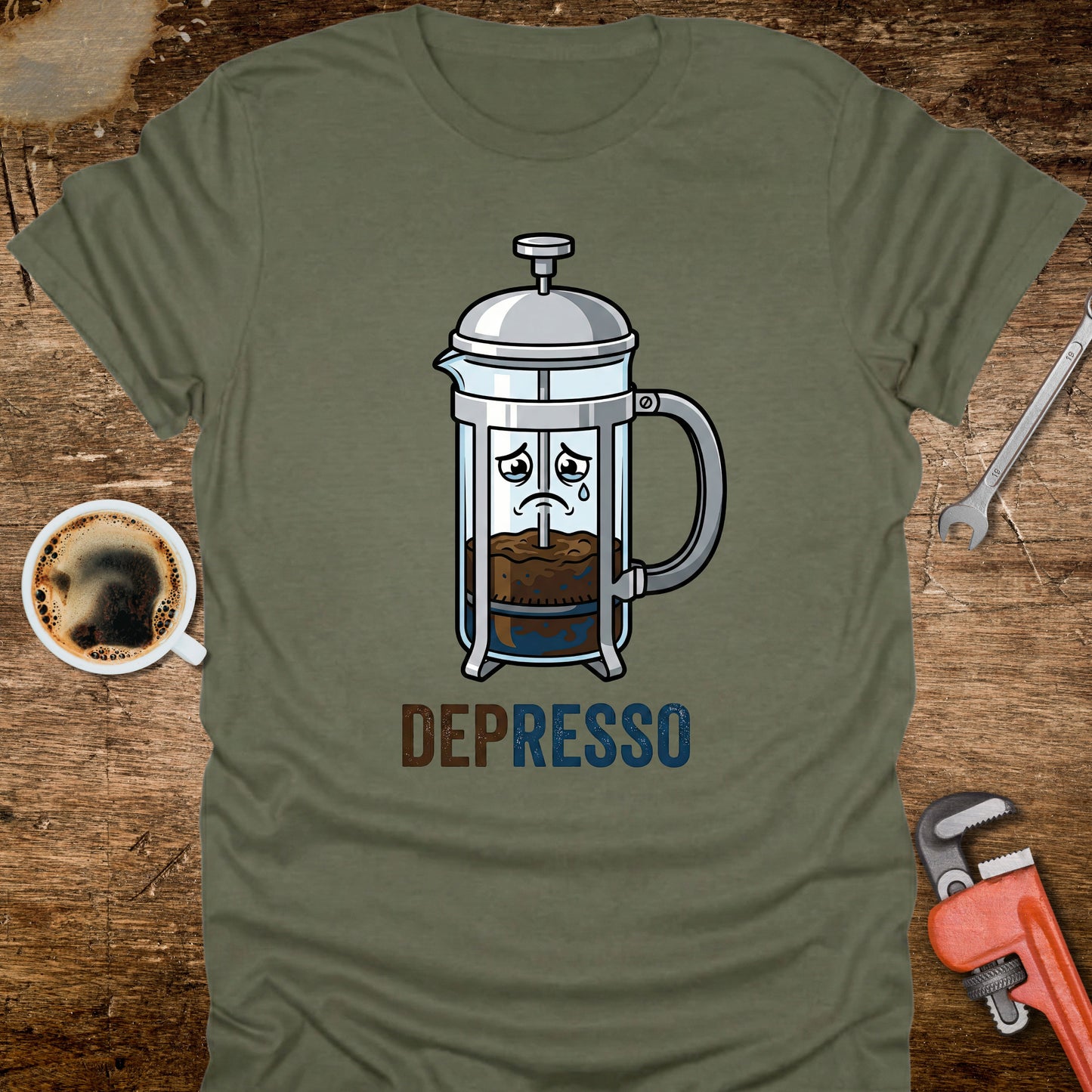 Green t-shirt with a coffee-themed graphic and 'DEPRESSO' text on a wooden surface with a coffee cup and tools.